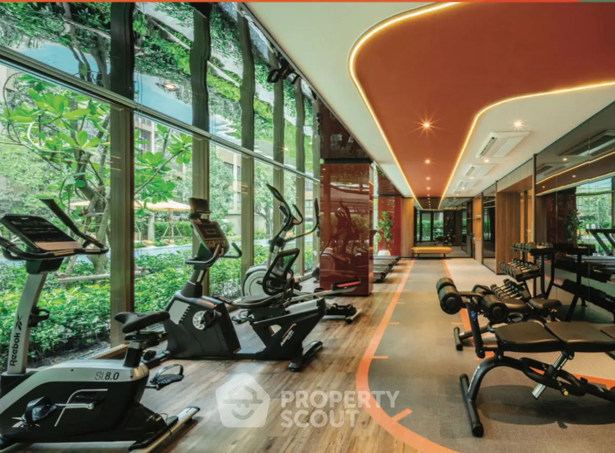 Luxurious gym with modern equipment and garden view, perfect for fitness enthusiasts.