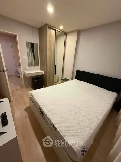 Cozy bedroom with modern furnishings and ample natural light, featuring a comfortable bed and sleek wardrobe.