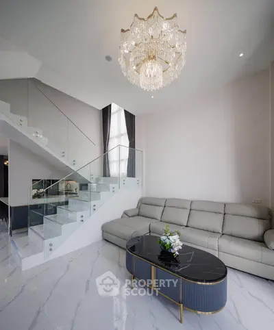 Luxurious living room with elegant chandelier and modern staircase