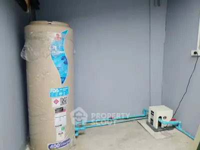 Spacious utility area featuring a large water heater and modern plumbing setup.