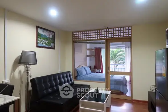 Cozy living room with modern decor and view into a stylish bedroom