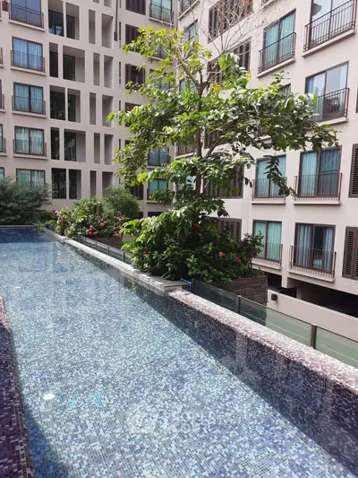Luxurious apartment complex with stunning pool and lush greenery, perfect for modern urban living.