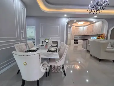 Luxurious open-layout dining and living area with elegant decor and modern kitchen.