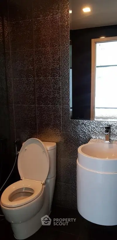 Modern bathroom with sleek fixtures and textured wall tiles