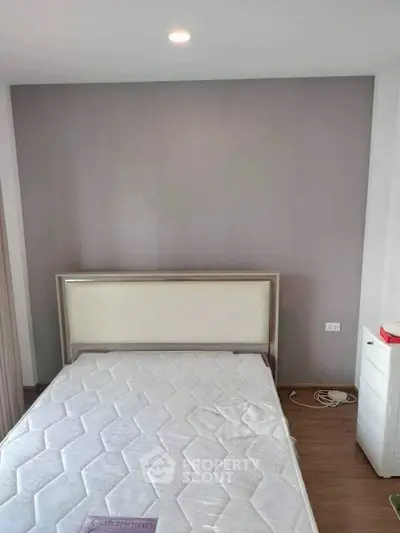 Modern bedroom with minimalist design featuring a comfortable bed and sleek wooden flooring.