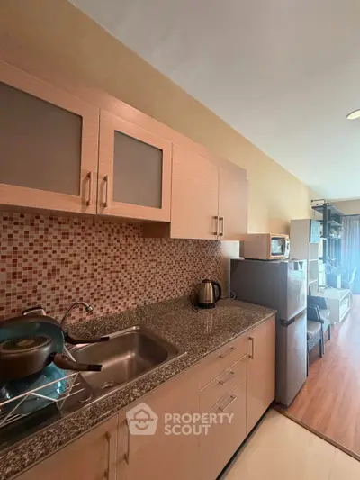 Modern kitchen with granite countertops and stylish cabinetry in a cozy apartment setting.