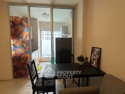Modern apartment dining area with colorful balcony view and sleek furniture.