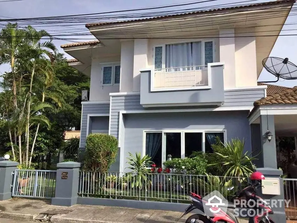 Charming two-story house with lush garden and modern facade in a serene neighborhood.