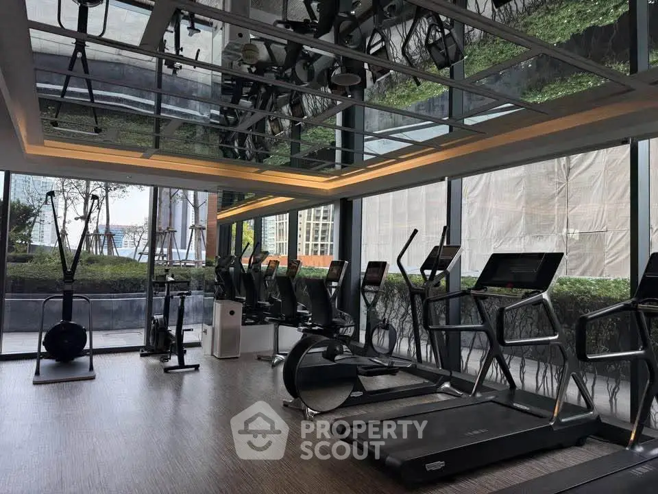 Luxurious gym with modern equipment and floor-to-ceiling windows offering stunning views.