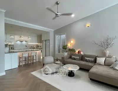 Modern living room with open kitchen, stylish decor, and cozy seating area.