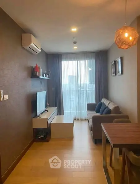 Modern living room with cozy sofa, TV, and stylish decor in a high-rise apartment.