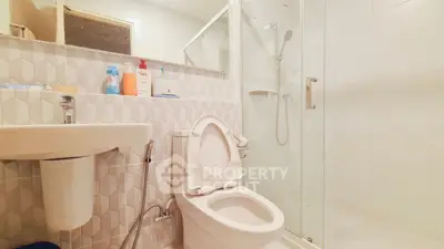Modern bathroom with shower and toilet in sleek white design