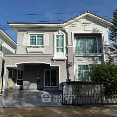 Elegant two-story house with modern facade and spacious driveway in a serene neighborhood.
