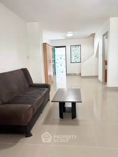 Spacious living room with modern sofa and sleek coffee table, perfect for relaxation and entertaining.