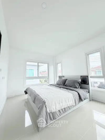 Bright and airy bedroom with modern decor and large windows in a contemporary home.