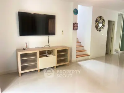 Modern living room with wall-mounted TV and stylish wooden cabinet