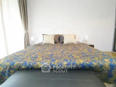 Luxurious bedroom with elegant floral bedding and soft lighting, perfect for relaxation and comfort.