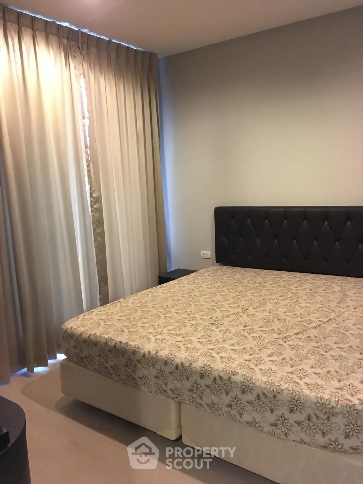 Cozy bedroom with elegant curtains and stylish headboard in modern apartment.
