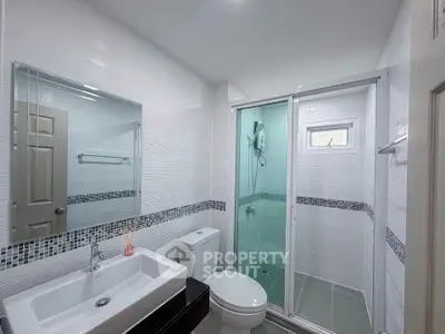 Modern bathroom with glass shower and sleek fixtures in a contemporary home.