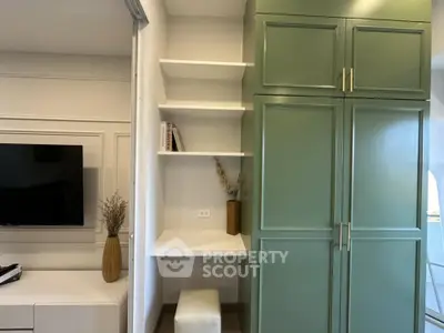 Modern interior with green cabinets and built-in desk in a stylish living space.