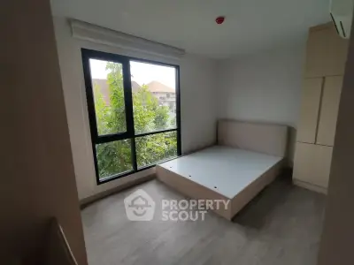 Spacious bedroom with large window and modern minimalist design