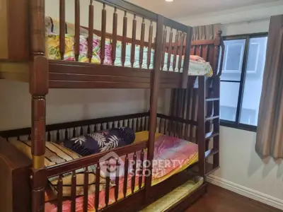 Cozy bedroom with wooden bunk beds and natural light from window