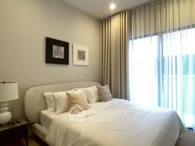 Elegant bedroom with modern decor and natural light through large window.
