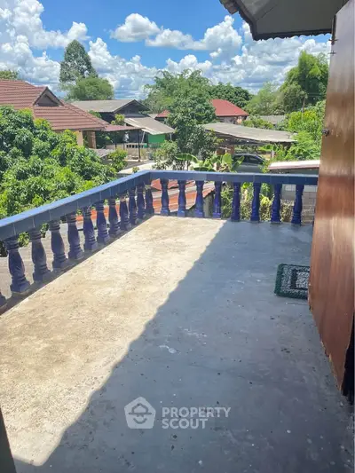 Spacious balcony with scenic neighborhood view and clear blue sky.