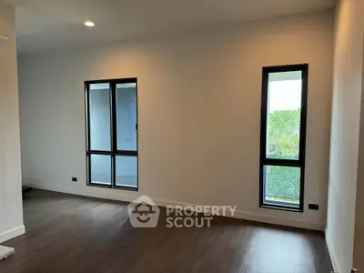 Spacious modern living room with large windows and hardwood floors