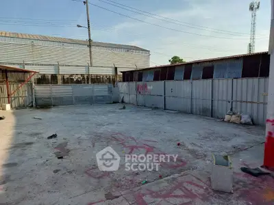Spacious outdoor area with concrete flooring and metal fencing, ideal for storage or parking.