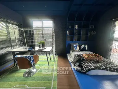 Stylish kids' bedroom with football-themed decor and modern furnishings.