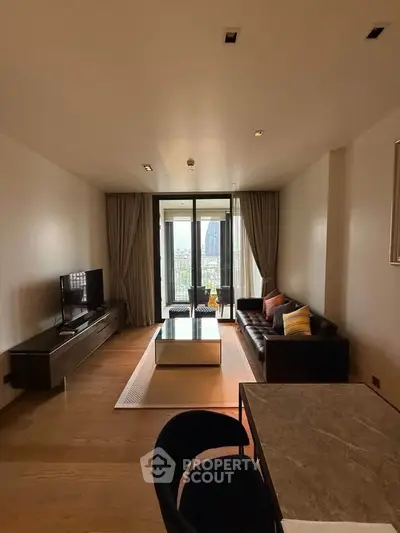 Modern living room with sleek furniture and city view balcony.