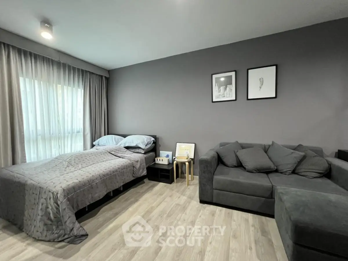 Modern bedroom with stylish gray decor and cozy seating area