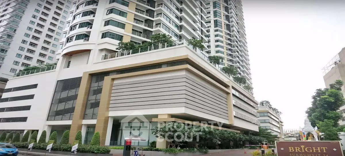 Modern high-rise building with lush greenery and stylish architecture in prime urban location.