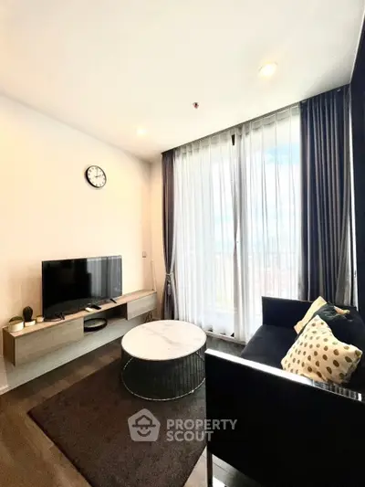 Modern living room with sleek furniture and large window view.