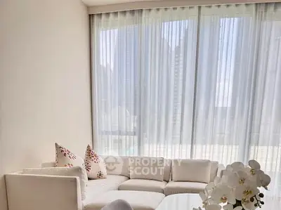 Elegant living room with plush white sofa and large windows offering natural light.