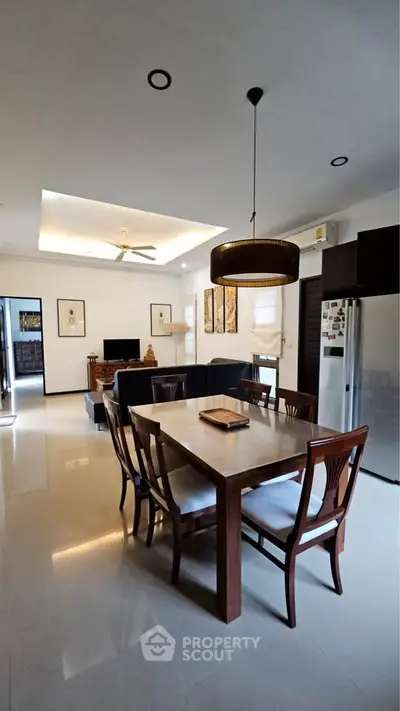 Spacious modern living room with dining area and elegant lighting, perfect for family gatherings.