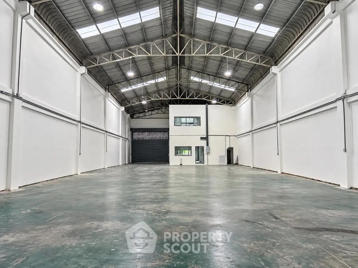 Spacious industrial warehouse with high ceilings and ample natural light, perfect for storage or manufacturing.