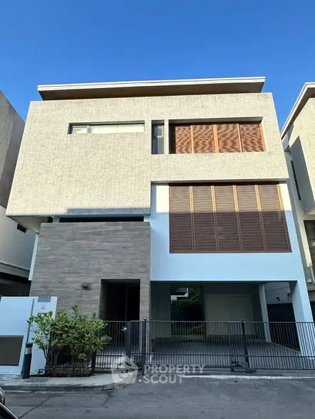 Modern three-story house with sleek design and gated entrance