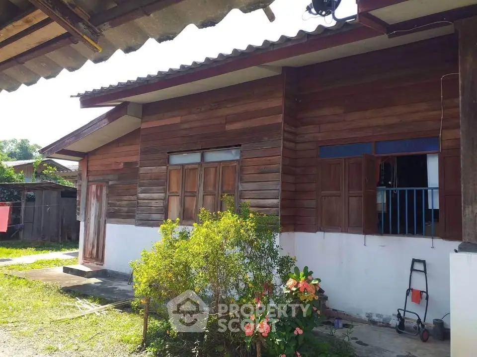 Charming rustic wooden house with lush garden and vibrant flowers, perfect for nature lovers.