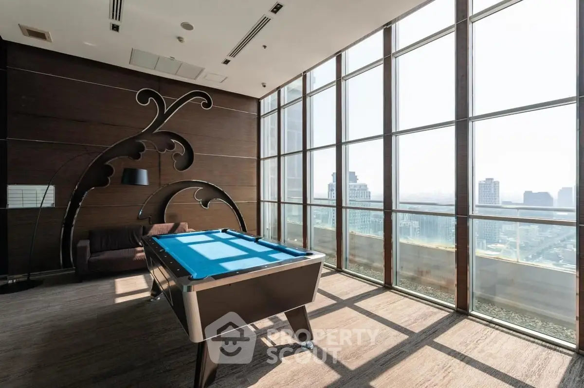 Luxurious high-rise apartment with stunning city view and billiards table in spacious living area.