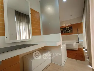 Modern bedroom with stylish decor and natural light, featuring a cozy bed and elegant furnishings.