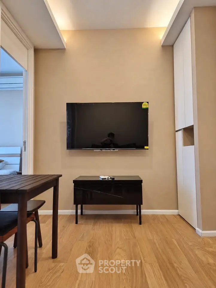 Modern living room with wall-mounted TV and stylish wooden flooring