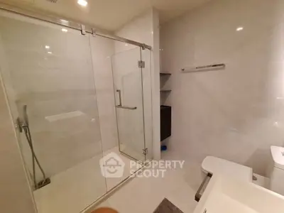 Modern bathroom with glass shower enclosure and sleek fixtures