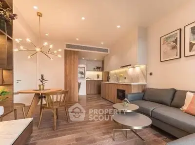 Modern living room with open kitchen, stylish lighting, and cozy seating area.