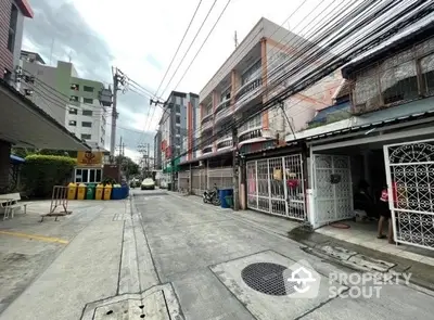 Charming urban street view with residential buildings and vibrant community atmosphere.