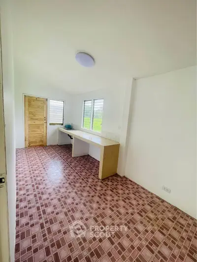 Bright room with tiled floor and wooden door, perfect for versatile use.