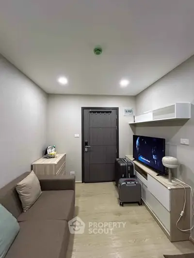 Cozy living room with modern decor, featuring a comfortable sofa, sleek TV unit, and stylish lighting.