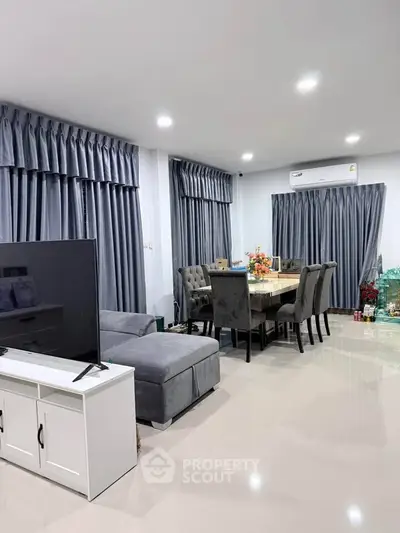 Spacious modern living room with elegant dining area and plush seating, perfect for family gatherings.