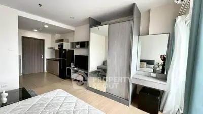Modern studio apartment with sleek furniture and open layout, featuring a cozy living area and stylish kitchenette.